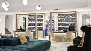 A modern hotel lobby with a green sofa, black armchair, and a reception desk.