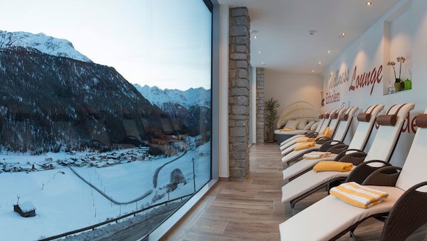 Una sala relax con vista su un paesaggio montano innevato.