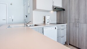 Ett modernt kök med diskmaskin, kaffebryggare och en inbyggd ugn.