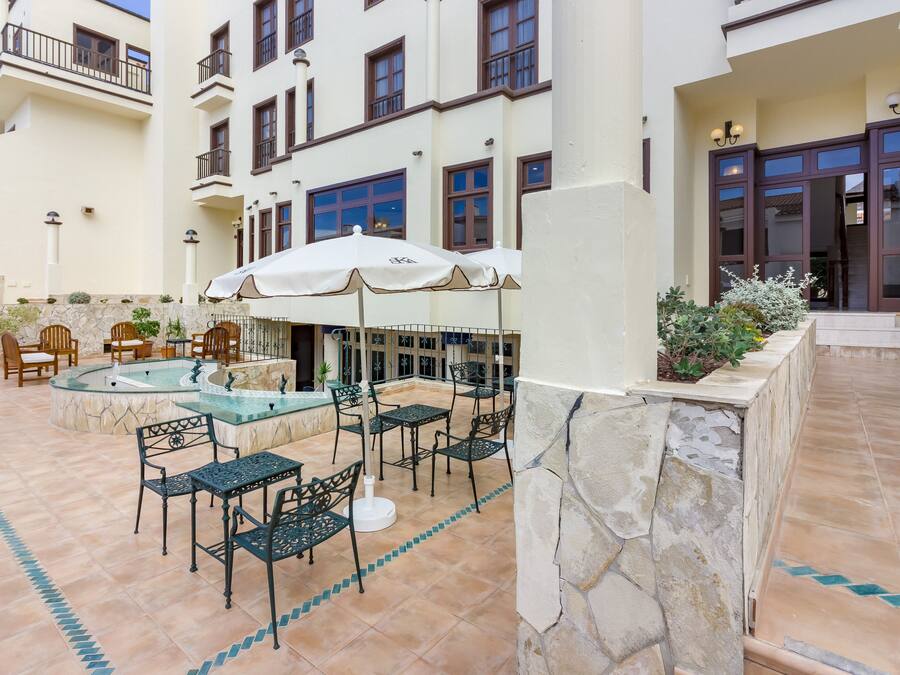 A pool area with outdoor seating and a stone wall.