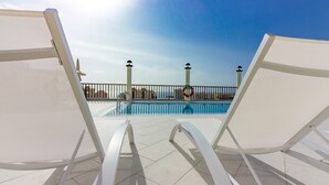 A poolside area with white lounge chairs and a clear view of the pool. - Klayman Olivina Aparthotel (Arona)