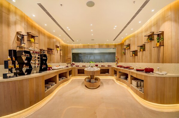 A modern, well-lit room with wooden paneling and a central circular table surrounded by shelves with various items. - Vividus (Bengaluru)