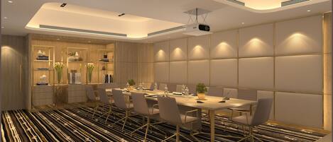 A modern conference room with a long table, chairs, and a projector.