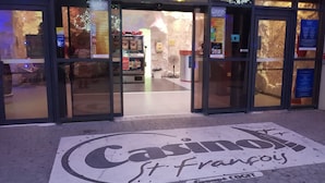 The entrance to a casino with glass doors and a sign reading "Casino St. Francois." - Touba Manga Beach (Saint-François)