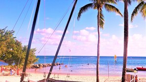 A beach with palm trees, a sandy shore, and the ocean. - Touba Manga Beach (Saint-François)
