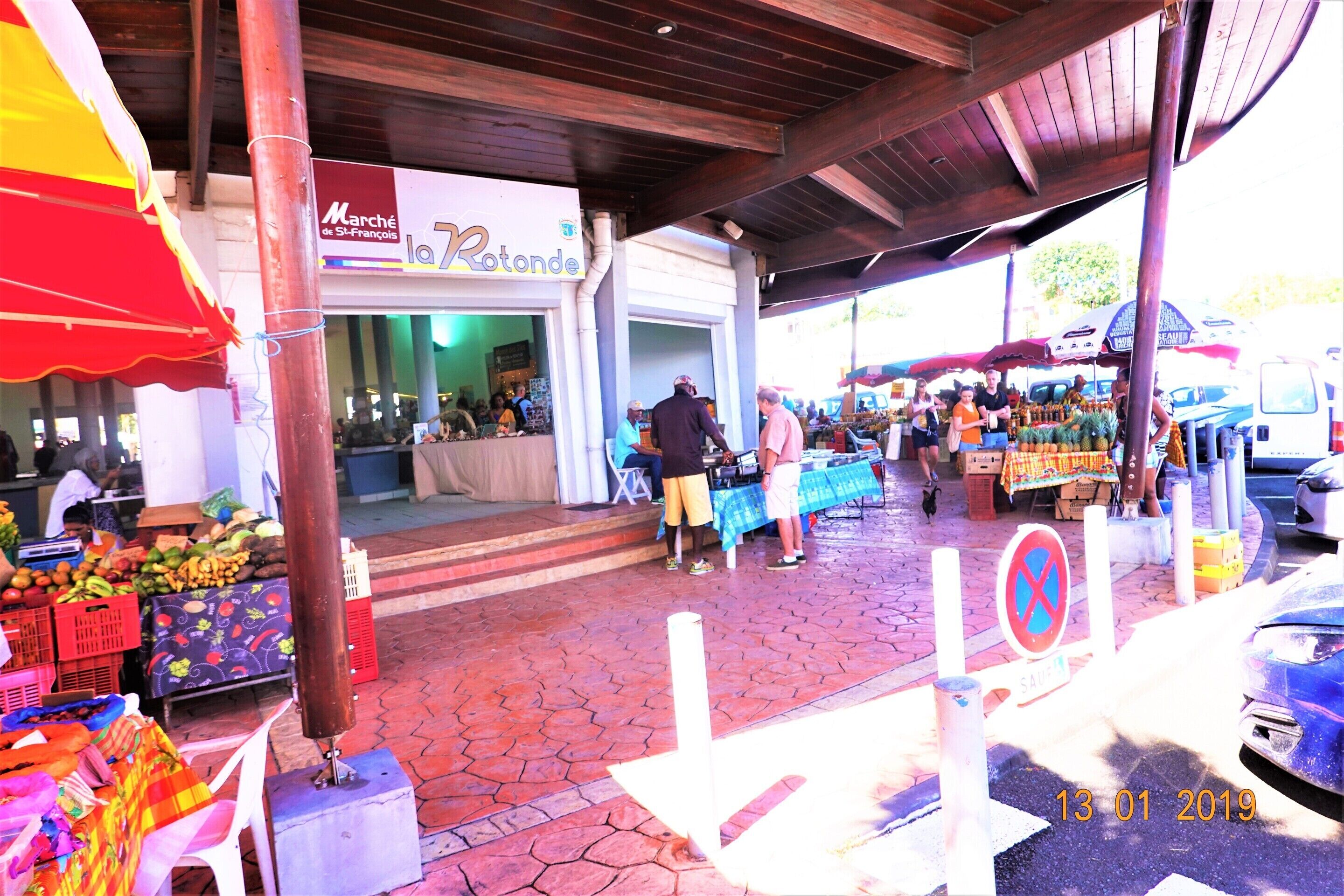 Un mercado al aire libre con varios puestos y una zona techada.