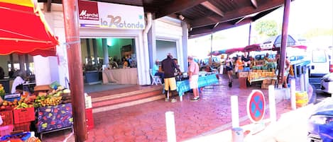 Un mercado al aire libre con varios puestos y una zona techada.
