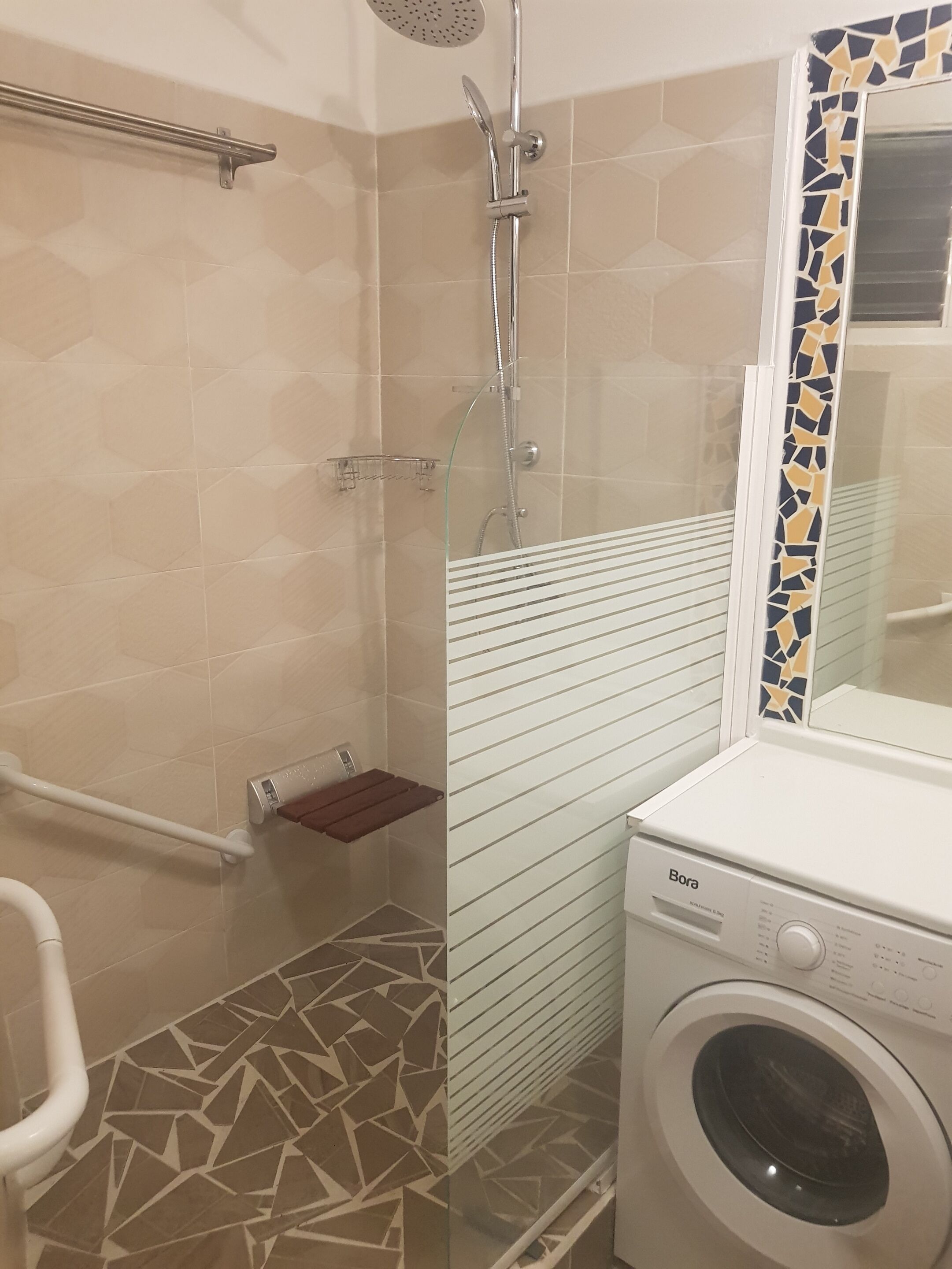 Une salle de bain avec une douche, des toilettes et un lave-linge.