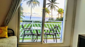 A room with a view of the ocean and palm trees through a window. - Touba Manga Beach (Saint-François)