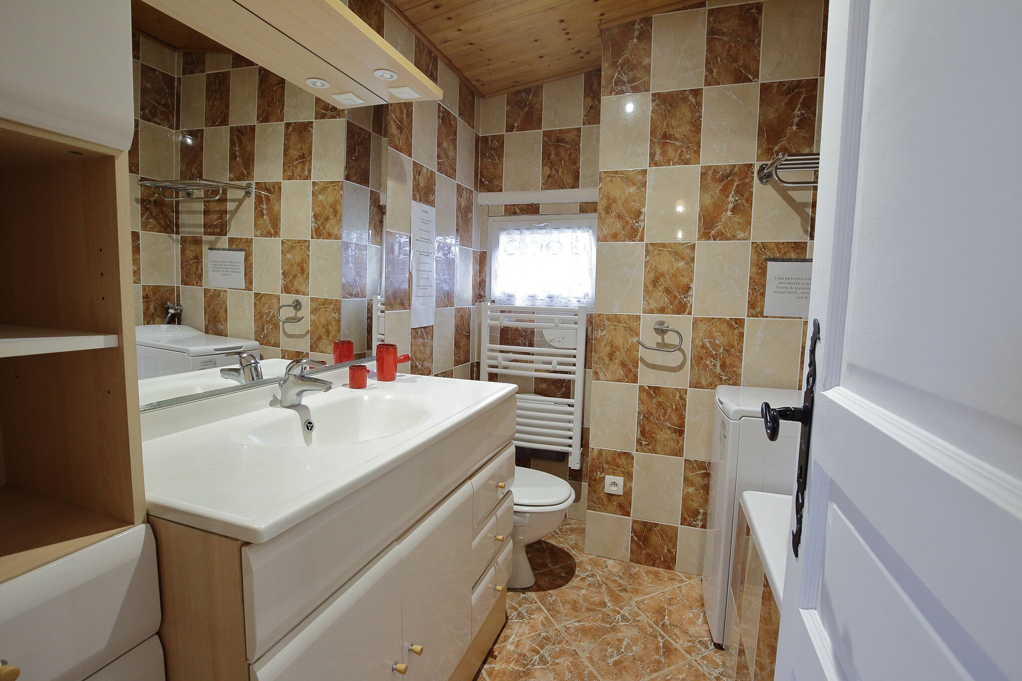 A bathroom with a double sink, white vanity, and a toilet.