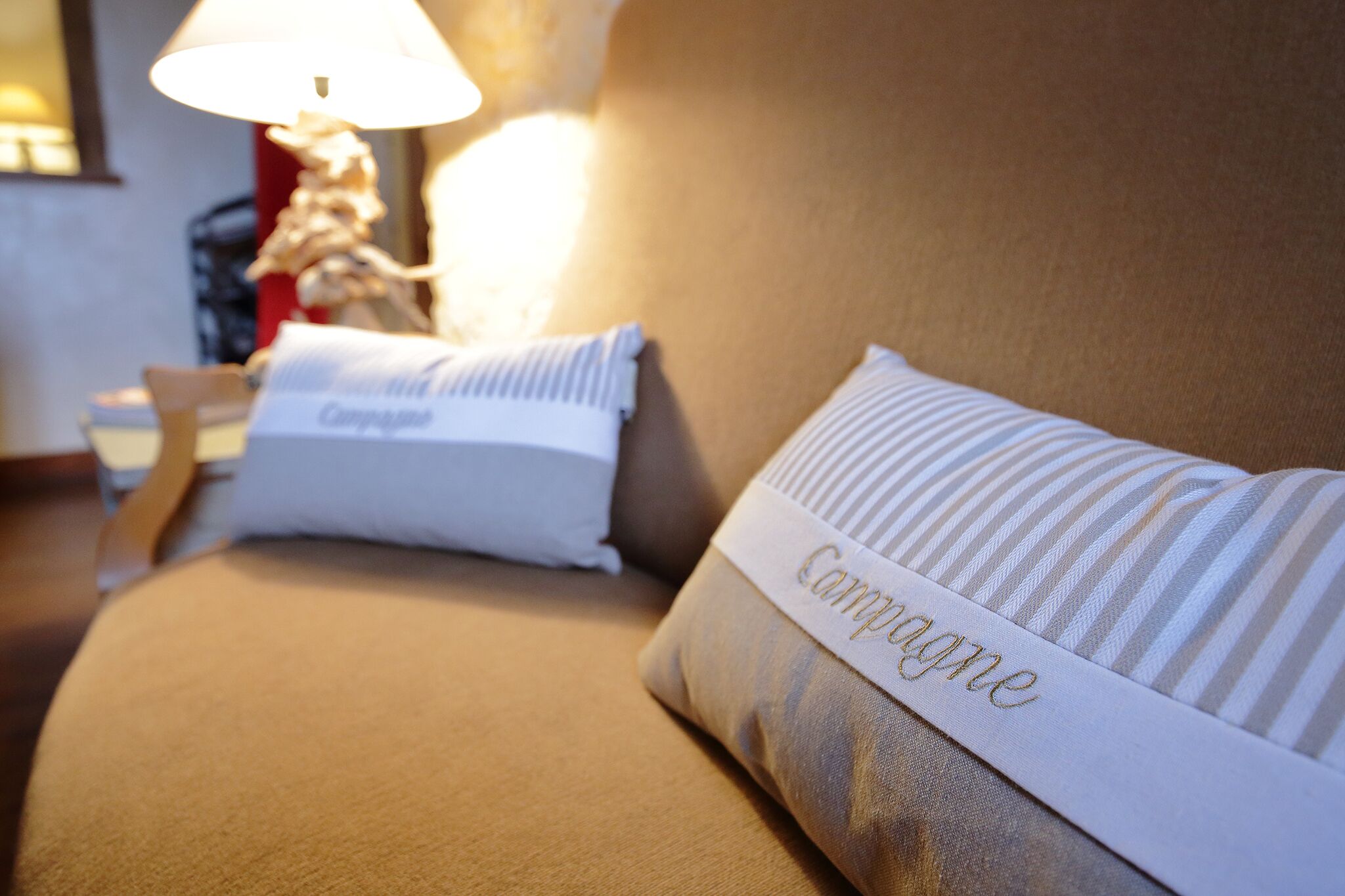 Een hotelkamer met een bed, een lamp en een decoratief object op het nachtkastje.