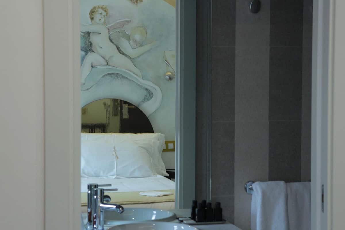 Un baño con un espejo grande, un lavabo y zona de ducha.