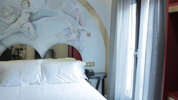 Una habitación de hotel con una cama, un teléfono y una pared con un mural decorativo.