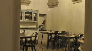 A dining area with a chandelier, checkered floor, and arched ceiling. - Locanda San Tomaso (Pietra Ligure)