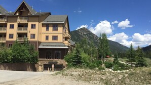A multi-story lodge with a stone facade and balconies, surrounded by mountains and trees. - 1BR/2 FULL Baths +Murphy bed & Sleeper Sofa, Sleeps 6, to Gondola in 337 steps (Keystone)