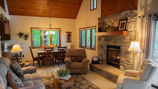 Una sala de estar acogedora con chimenea, asientos cómodos y un comedor.