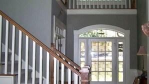 Un escalier avec des rampes blanches et des marches en bois menant à un palier.
