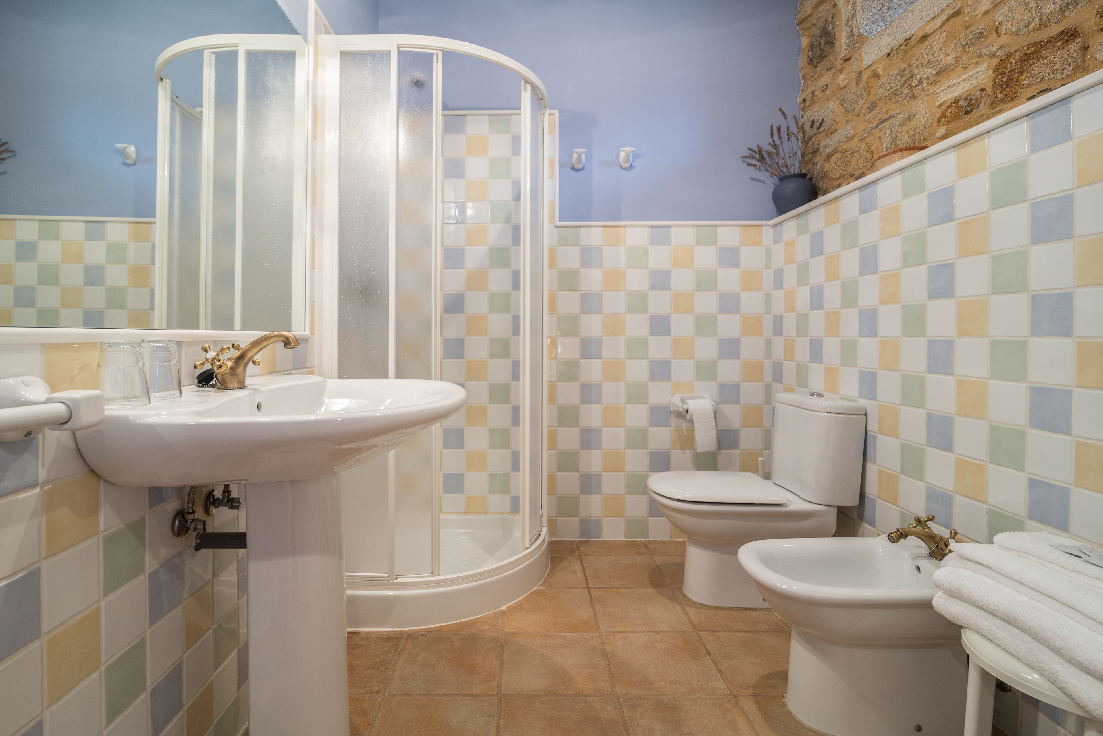Un baño con cabina de ducha, lavamanos, inodoro y bidé.