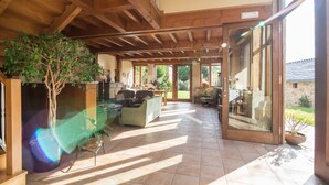 Un salón amplio con un gran árbol, asientos cómodos y vistas al exterior.
