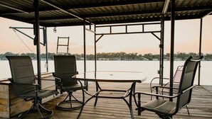 An outdoor seating area with a table and chairs, overlooking a body of water.