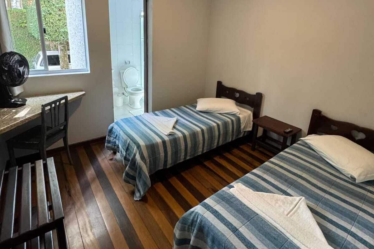 A room with two beds, a desk, and a chair.