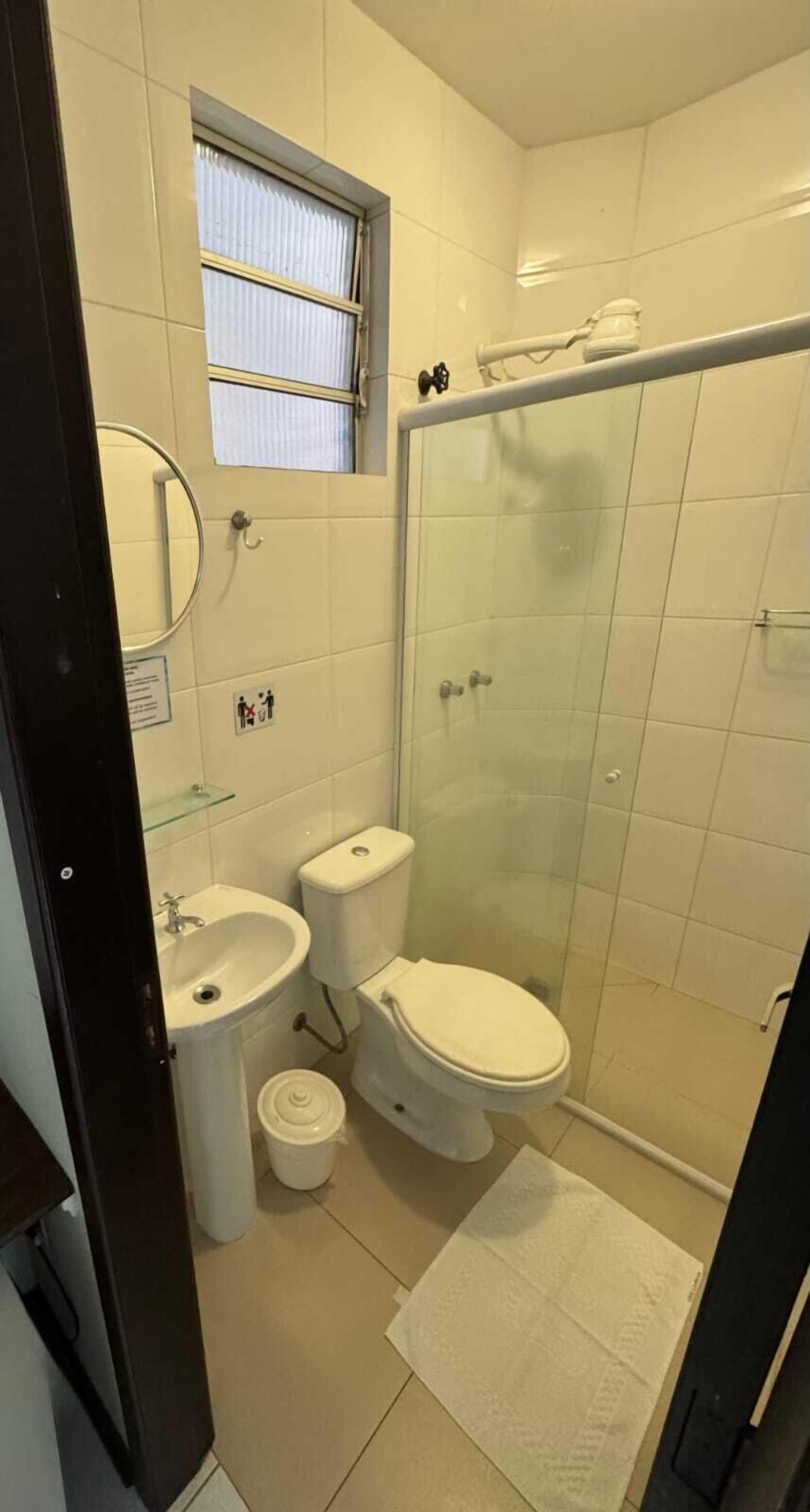 Ein kleines, kompaktes Badezimmer mit Toilette, Waschbecken und Duschkabine.