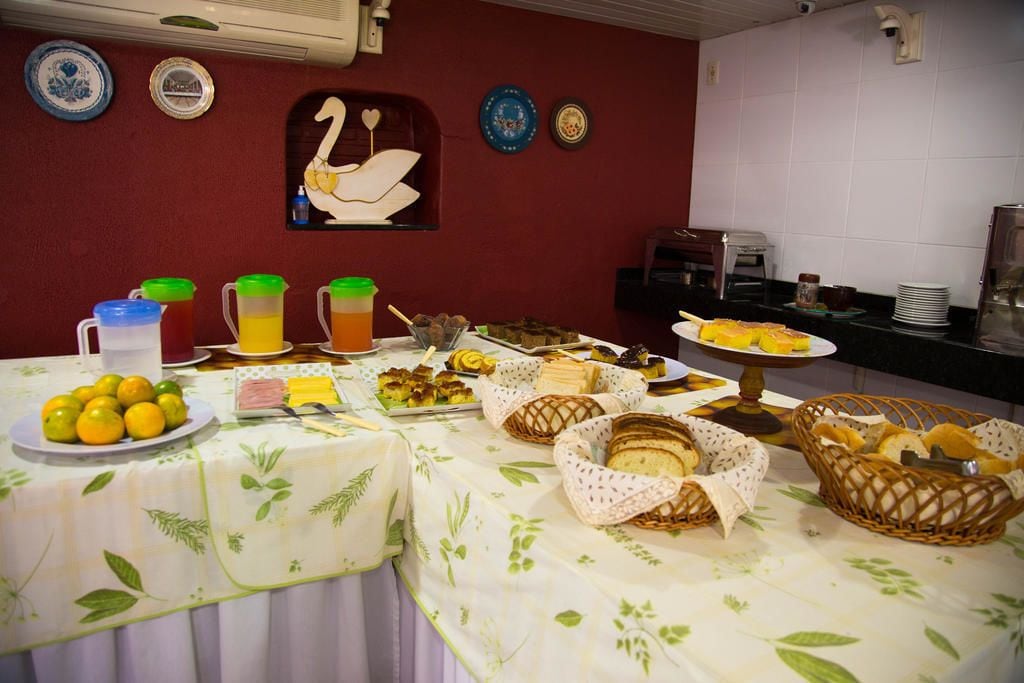 Una mesa de buffet con diversas opciones de comida, como frutas, pasteles y bebidas.