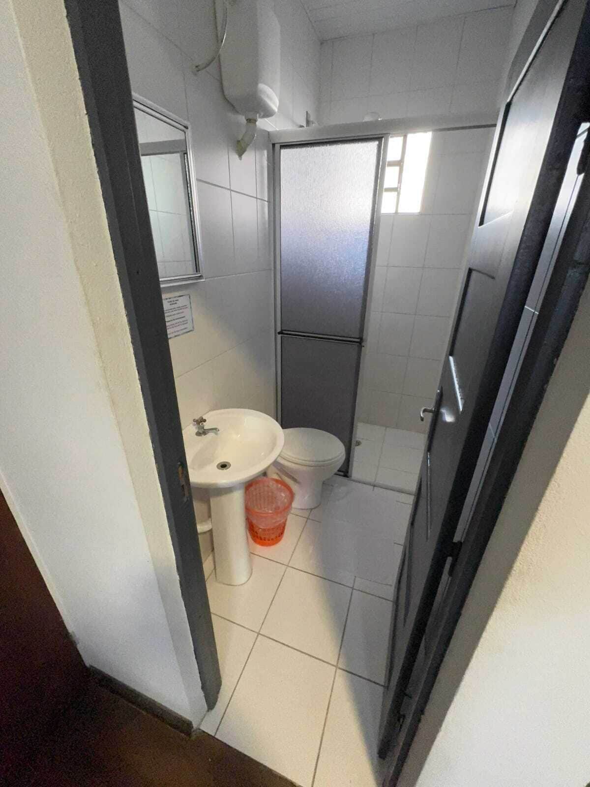 A compact bathroom with a sink, toilet, and shower area.