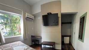 Una habitación de hotel con dos camas, televisión, escritorio y una silla.