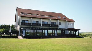 A two-story building with a flat roof, large windows, and a balcony. - Hotel Waldschlösschen (Werra-Suhl-Tal)