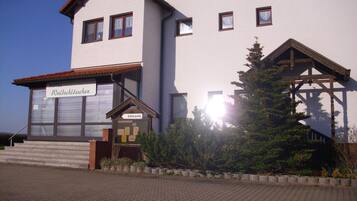 A hotel with a sign reading "Waldschlösser EINGANG" and a wooden structure in front.
