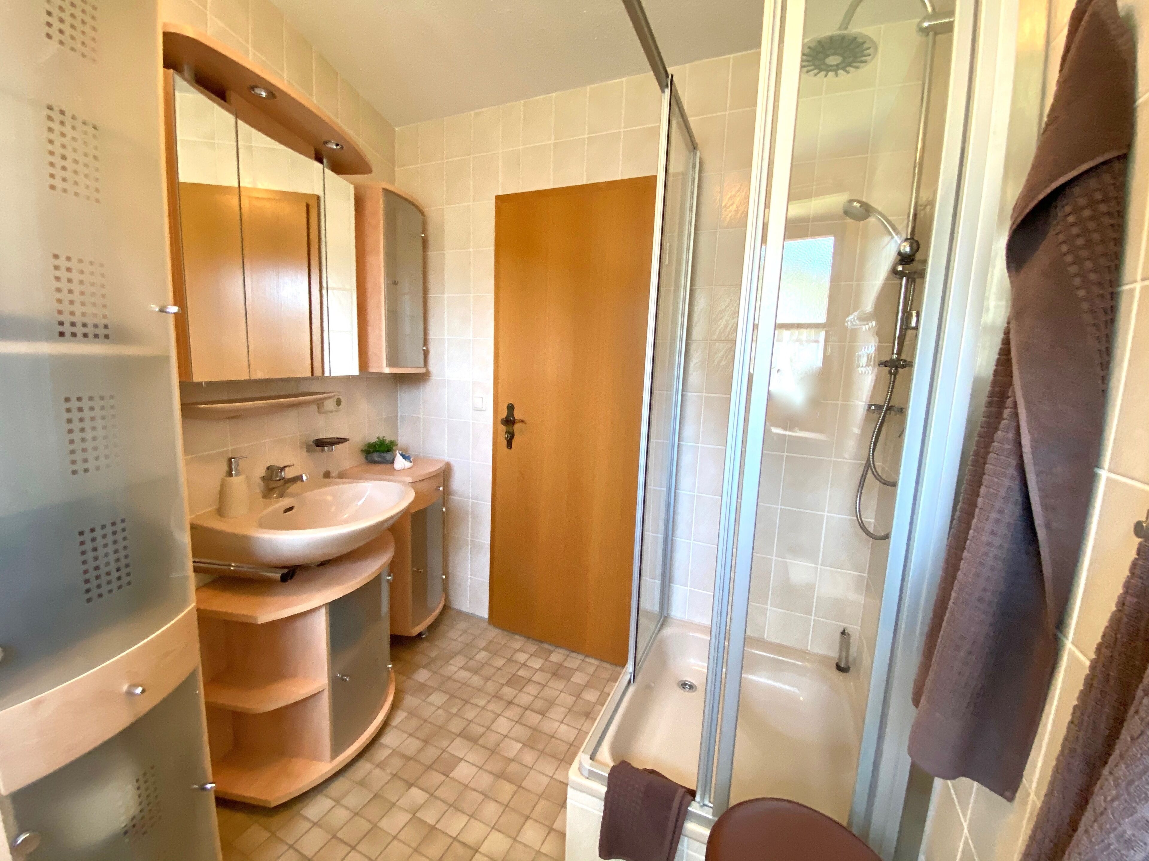 Une salle de bain avec un lavabo, un miroir et une douche.