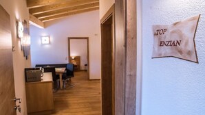 Et hotelværelse med trægulv, træloft, et skrivebord med computer, en stol og en seng.