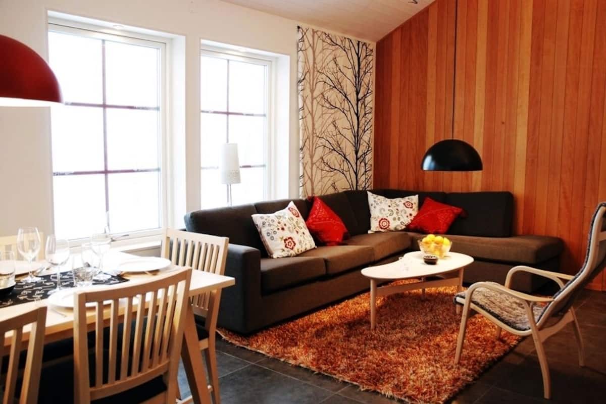 A cozy living room with a sofa, a dining table, and a coffee table.