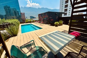 室外游泳池，提供遮陽小屋 (付費)和日光浴躺椅