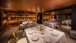 A dining area with multiple tables set for guests, featuring white tablecloths and gold accents. - Auténtico Monterrey (San Pedro Garza García)