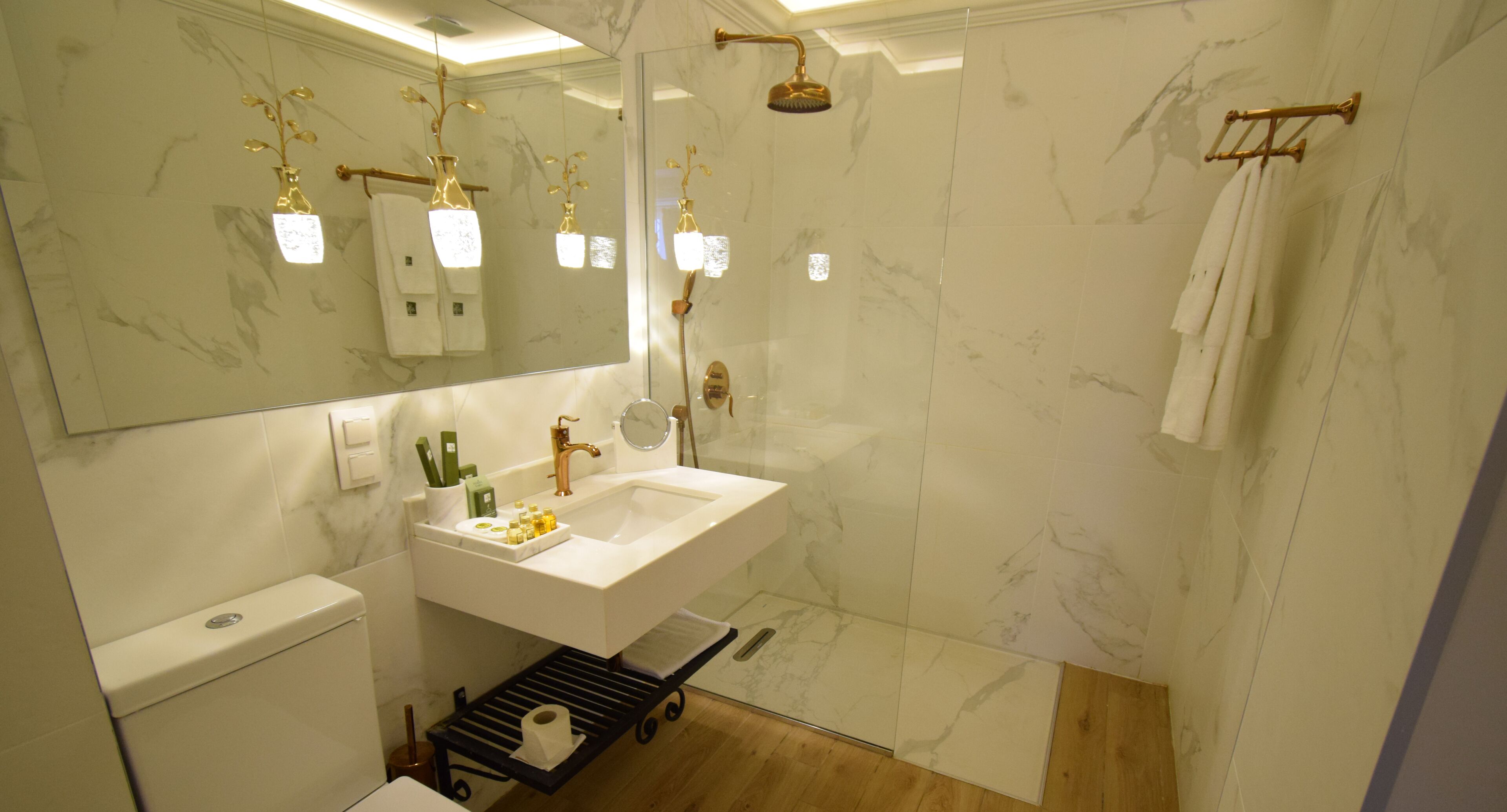 Ein modernes Badezimmer mit einem großen Spiegel, einem Waschbecken, einer Toilette und einer Dusche.