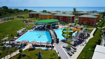 Relax by the resort's large pool, surrounded by lush greenery and a stunning sea view.