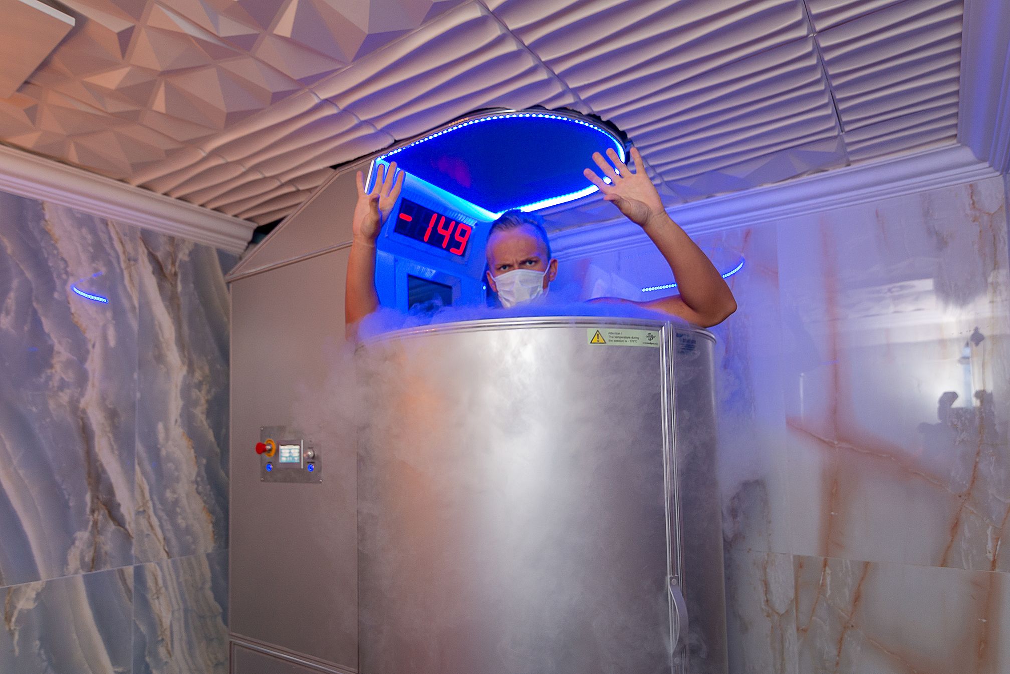 A person inside a metallic elevator with a digital display showing "-149".