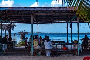 A beachside restaurant with outdoor seating and a view of the ocean. - Explora San Blas (Panama City)