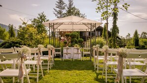 A gazebo with a white tablecloth and chairs arranged in a semi-circle.