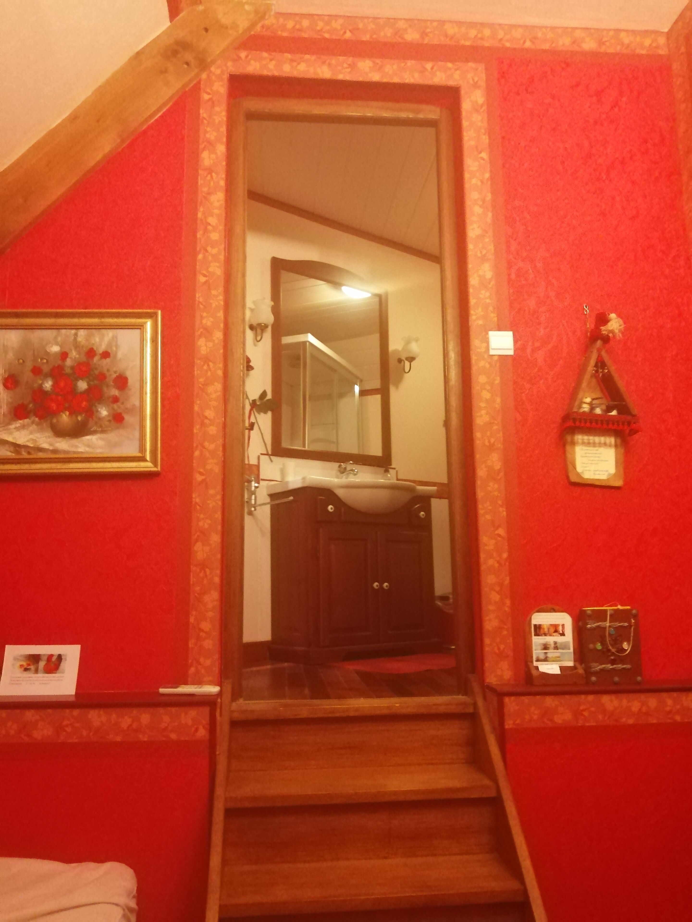 A staircase leading to a bathroom with a sink and mirror.