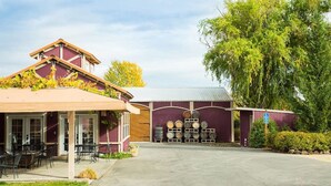 A building with a covered patio area and a barrel storage facility. - Wine Suite at Rellik House. Winery & Alpaca Farm (Central Point)