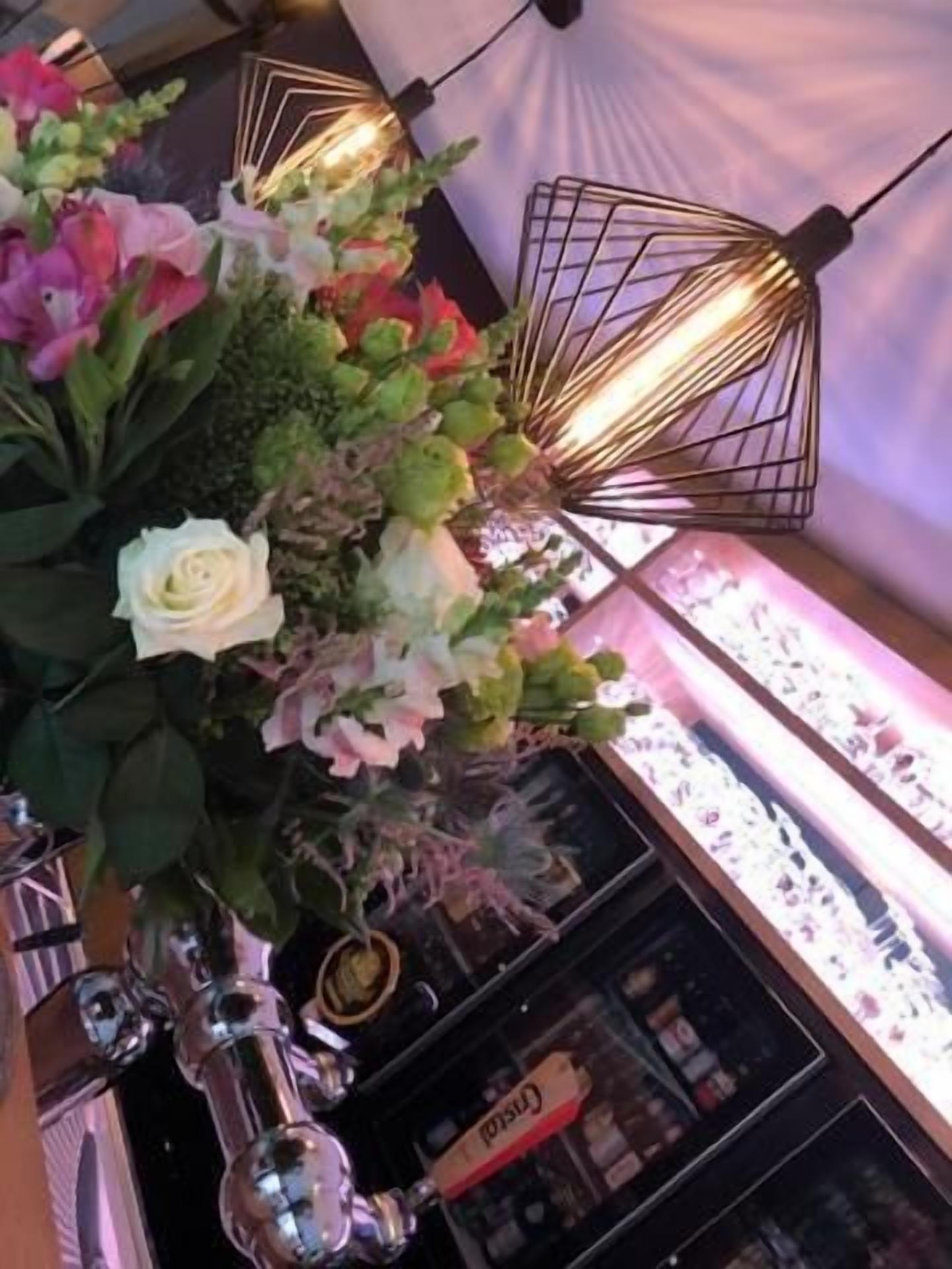 A floral arrangement with a variety of flowers and a decorative light fixture.