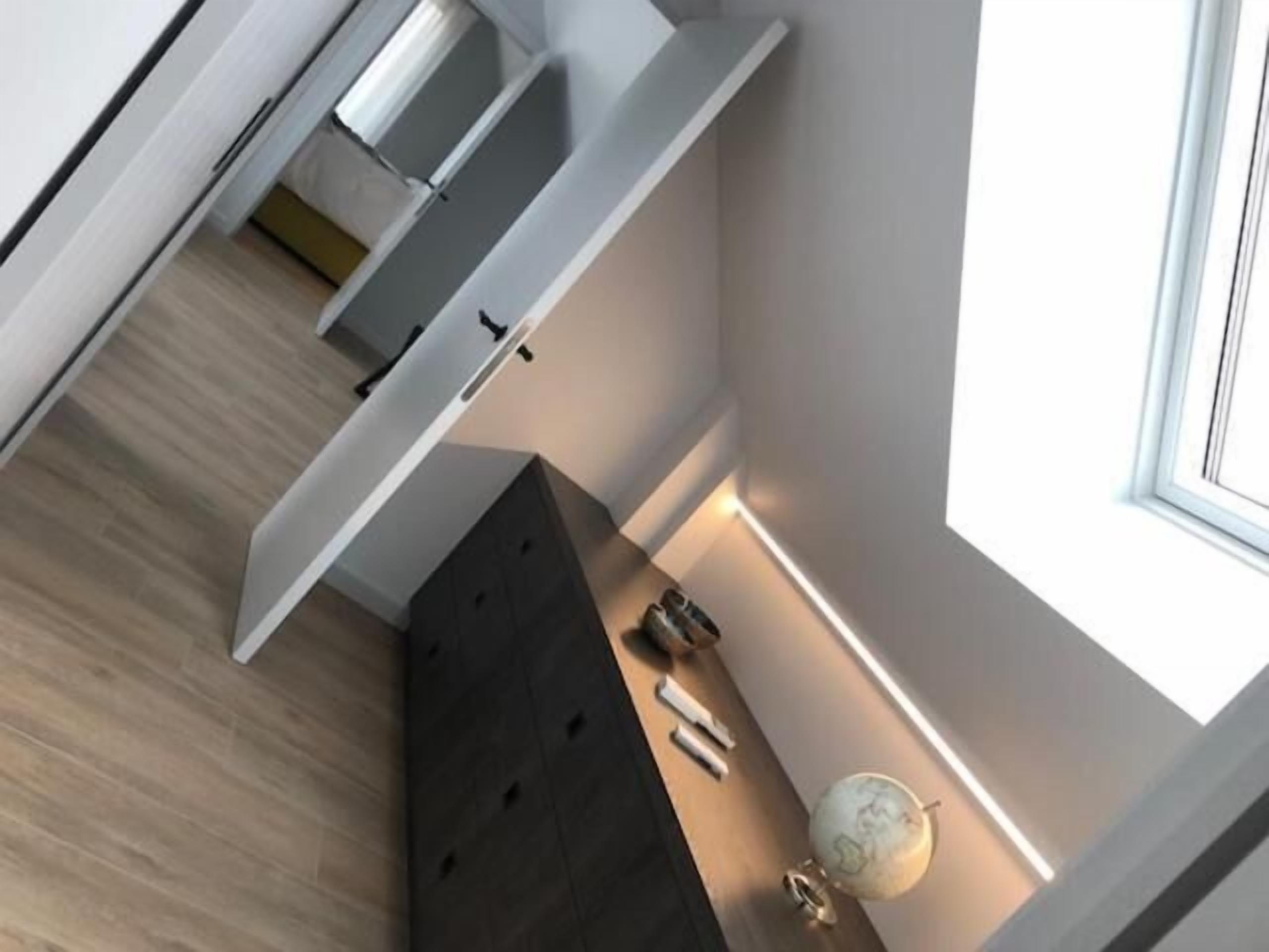 Una cocina moderna y compacta con horno empotrado y encimera oscura.