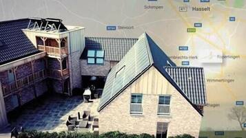 A model of a building with a courtyard, a covered area, and a traditional house with a sloped roof.