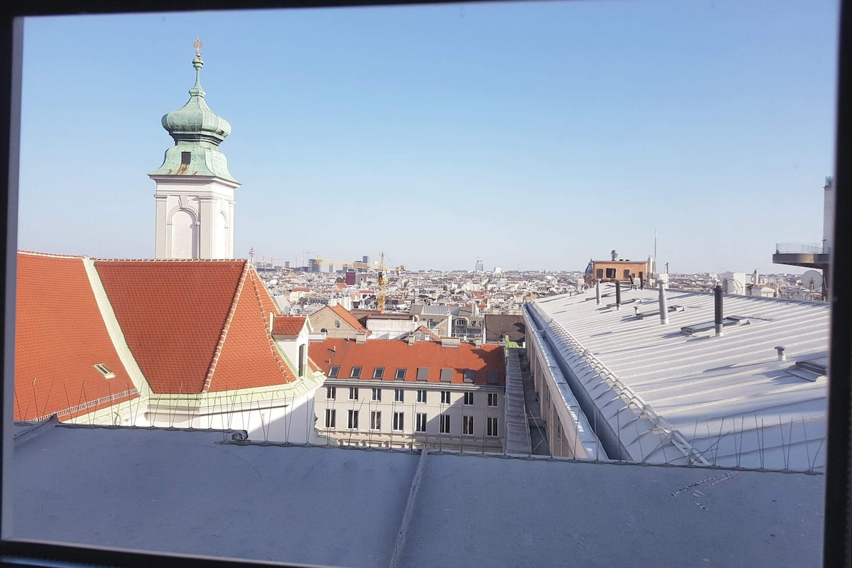Une vue urbaine avec un clocher d’église imposant et une variété de toits.