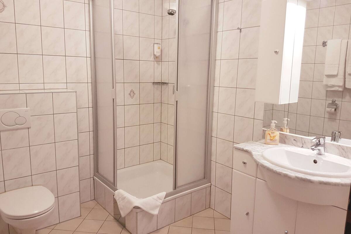 Une salle de bain moderne avec une douche à parois de verre, des toilettes et un lavabo avec un miroir.