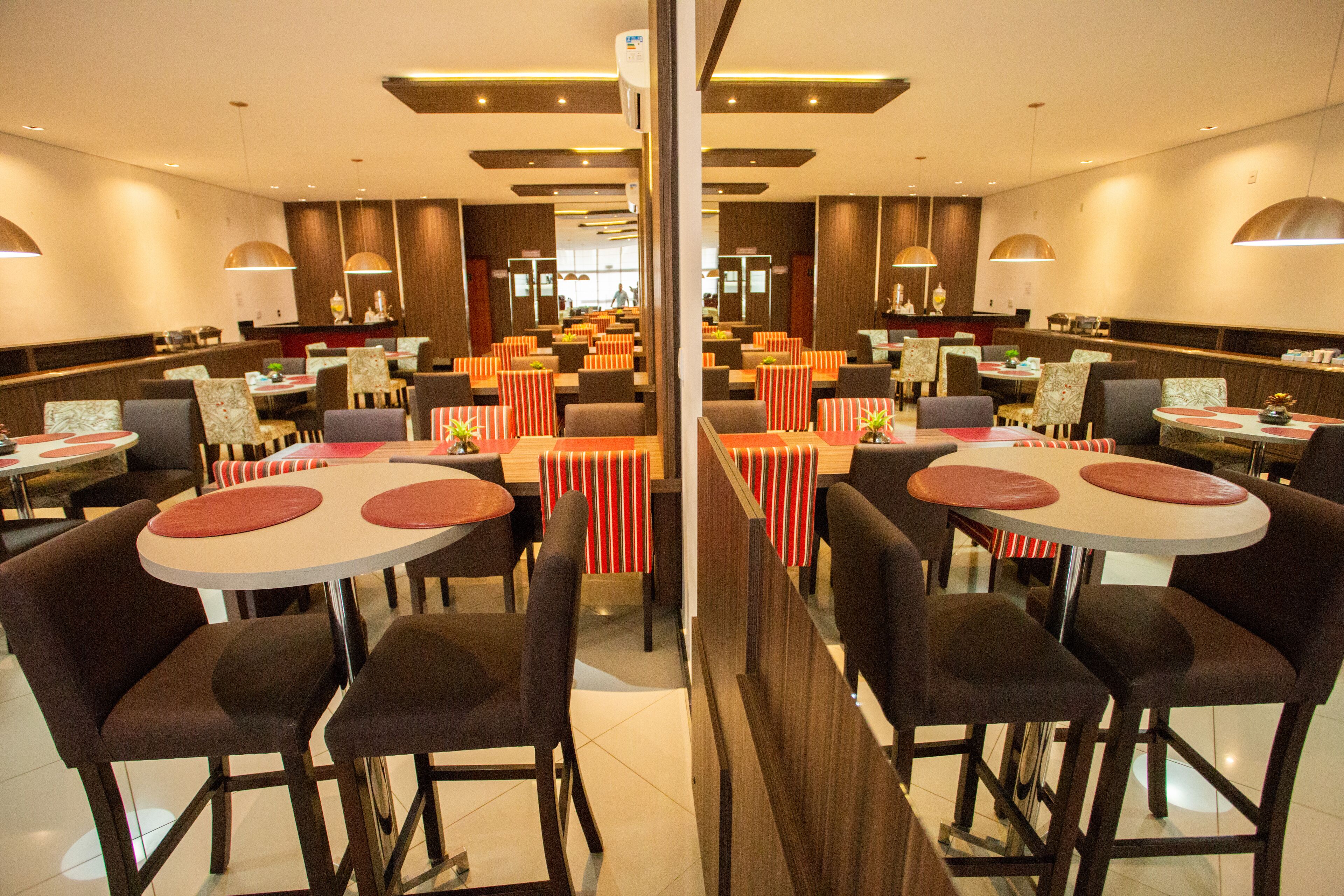 Un restaurante espacioso con varias zonas de comedor, cada una con mesas y sillas redondas.