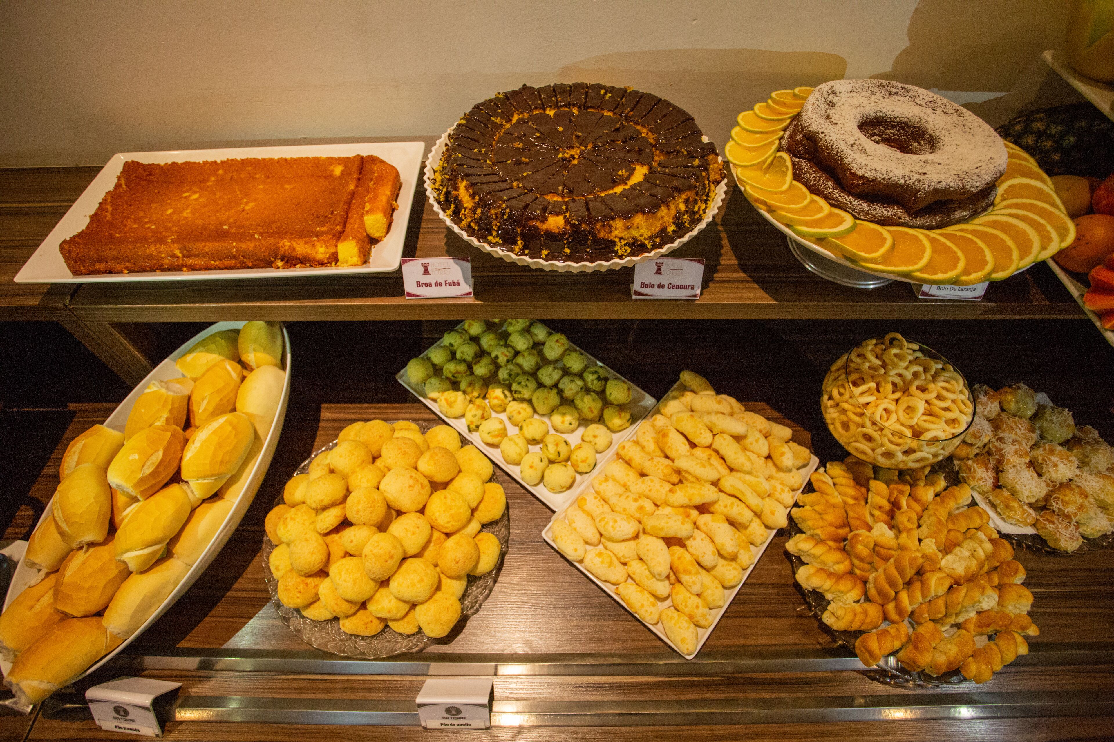 En buffet med forskellige spiser, heriblandt kager, wienerbrød og brød.